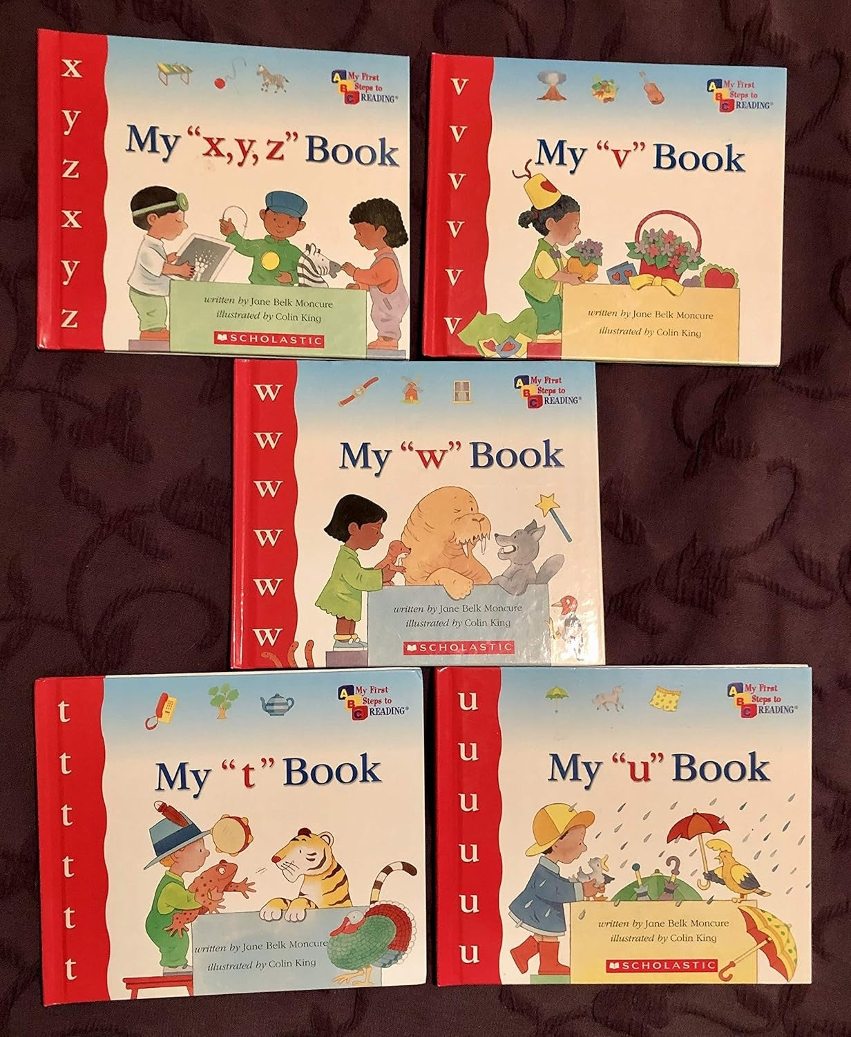 Set of five children's books titled 'My 'x', 'y', 'z' Book', 'My 'v' Book', 'My 'w' Book', 'My 't' Book', and 'My 'u' Book' on a dark background.