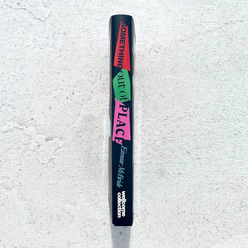 Black makeup product with colorful text on a textured white background