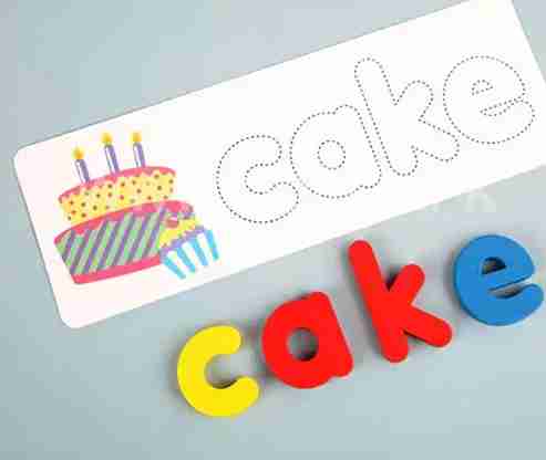 Colorful magnetic letters spelling 'cake' on a white card with a cake illustration.