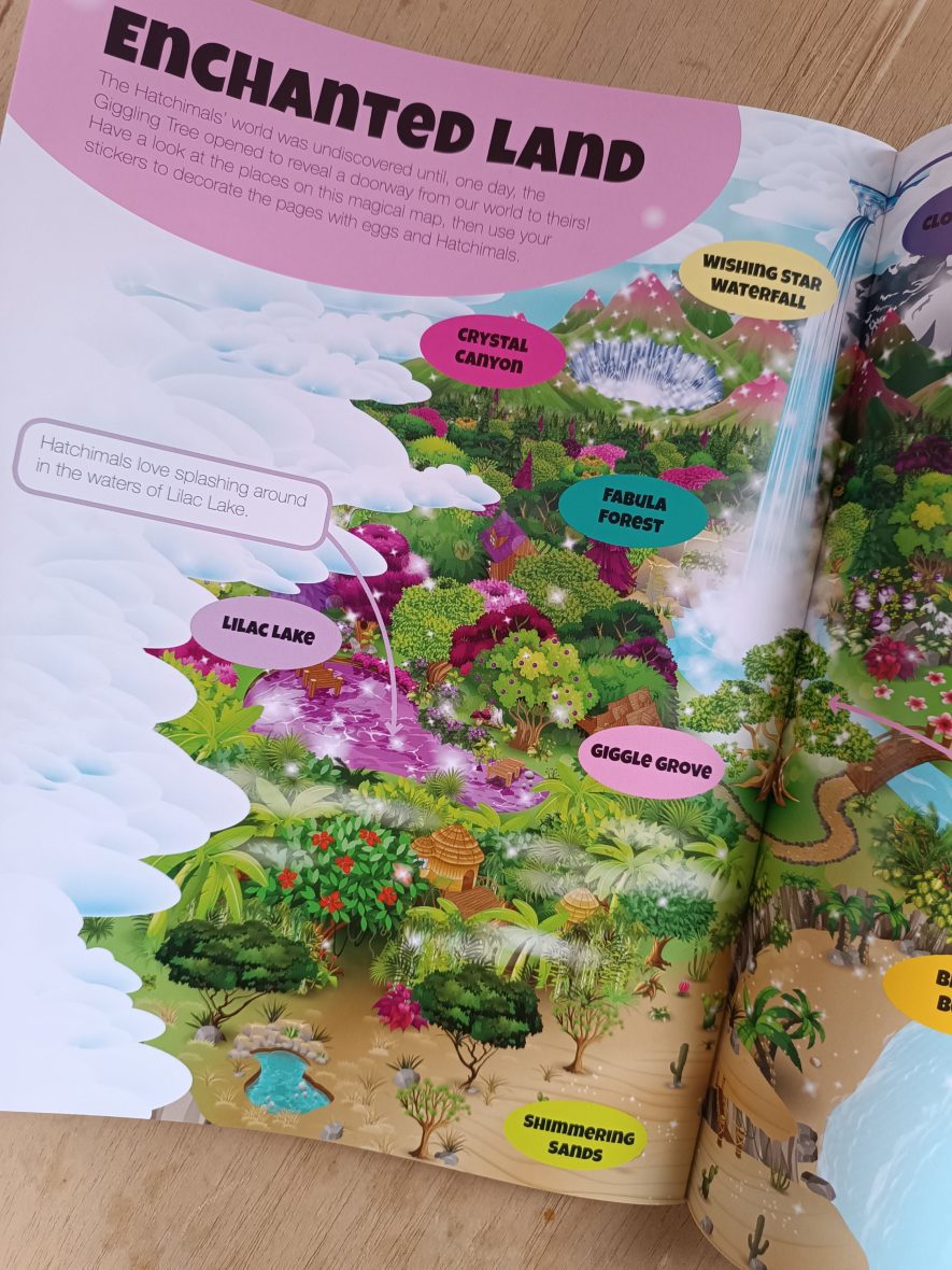 Children's book open to a page titled 'Enchanted Land' with colorful illustrations and labels.
