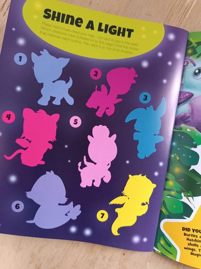 Colorful silhouette stickers on a purple sheet with 'Shine A Light' text, on a wooden surface.